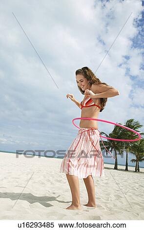 Teenage girl (16-17) playing with hoola hoop on beach View Large Photo Image Stock Photography - Teenage girl (16-17) playing with hoola hoop on beach. Fotosearch
