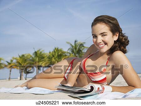 Teenage girl (16-17) reading magazine lying on beach portrait View Large Photo Image Stock Image - Teenage girl (16-17) reading magazine lying on beach portrait. Fotosearch