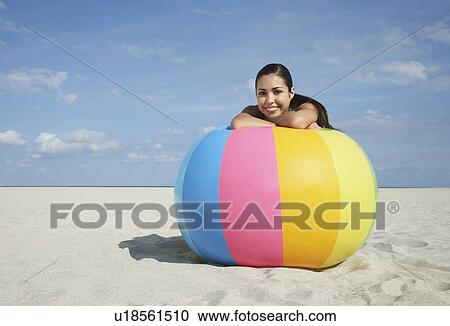 Teenage girl (16-17) sitting behind beach ball on beach portrait View Large Photo Image Stock Image - Teenage girl (16-17) sitting behind beach ball on beach portrait. Fotosearch