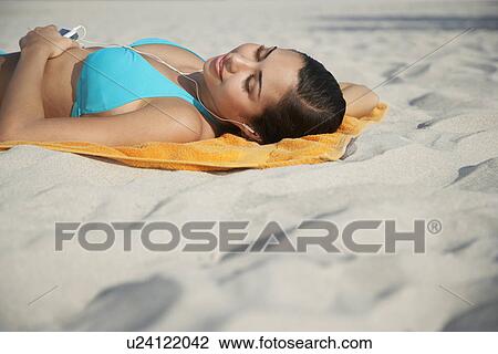 Teenage girl (16-17) using mp3 player lying on beach View Large Photo Image Stock Image - Teenage girl (16-17) using mp3 player lying on beach. Fotosearch
