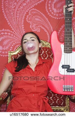 Teenage Girl sitting blowing bubble Holding up Guitar View Large Photo Image Stock Image - Teenage Girl sitting blowing bubble Holding up Guitar. Fotosearch