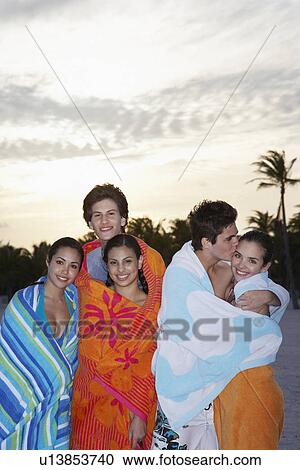 Teenagers (16-19) wrapped in towels on beach View Large Photo Image Stock Image - Teenagers (16-19) wrapped in towels on beach. Fotosearch