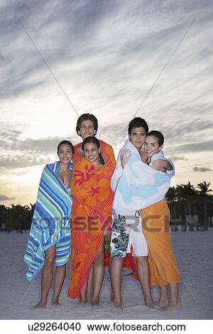 Teenagers (16-19) wrapped in towels on beach View Large Photo Image Stock Image - Teenagers (16-19) wrapped in towels on beach. Fotosearch