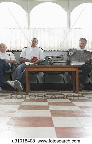 Stock Photo - Three barbers waiting for customers in barber shop. Fotosearch