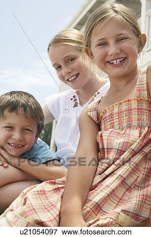 Three children (5-6 7-910-12) sitting outdoors portrait View Large Photo Image Stock Photo - Three children (5-6 7-910-12) sitting outdoors portrait. Fotosearch