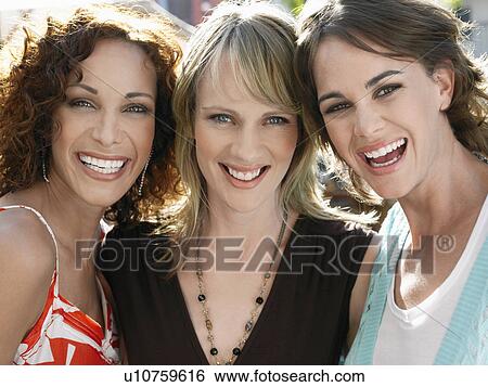 Stock Photograph - Three female friends smiling outdoors portrait. Fotosearch