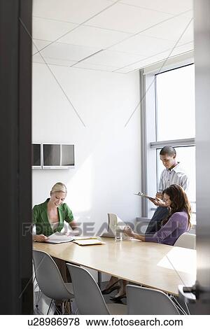 Stock Photo - Three office workers in conference room. Fotosearch