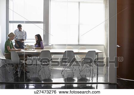 Stock Photograph - Three office workers in conference room. Fotosearch