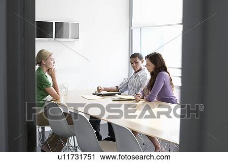 Three office workers sitting in conference room View Large Photo Image Stock Image - Three office workers sitting in conference room. Fotosearch