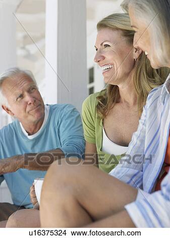 Three people sitting on verandah View Large Photo Image Picture - Three people sitting on verandah. Fotosearch