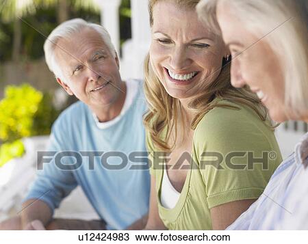 Three people sitting on verandah View Large Photo Image Stock Image - Three people sitting on verandah. Fotosearch