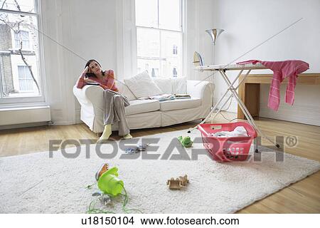 Picture - Tired housewife relaxing on sofa. Fotosearch