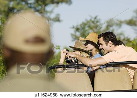 Tourists on safari pointing guide in foreground View Large Photo Image Stock Photo - Tourists on safari pointing guide in foreground. Fotosearch