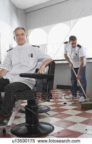 Two barbers in barber shop one sweeping floor View Large Photo Image Stock Photography - Two barbers in barber shop one sweeping floor. Fotosearch