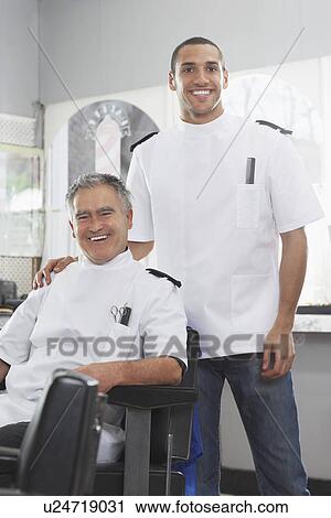 Stock Image - Two barbers in barber shop portrait. Fotosearch