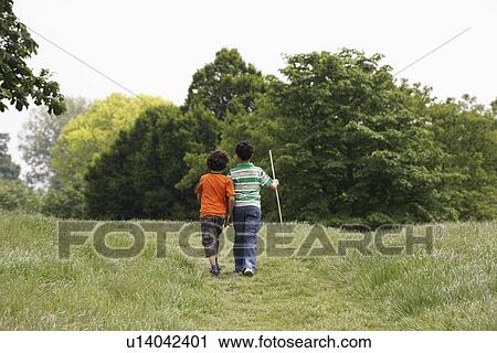 Two brothers (7-9) walking in field View Large Photo Image Stock Image - Two brothers (7-9) walking in field. Fotosearch