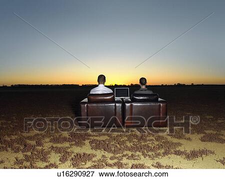 Two business people in arm chairs in open plain at sunset back view View Large Photo Image Stock Photo - Two business people in arm chairs in open plain at sunset back view. Fotosearch