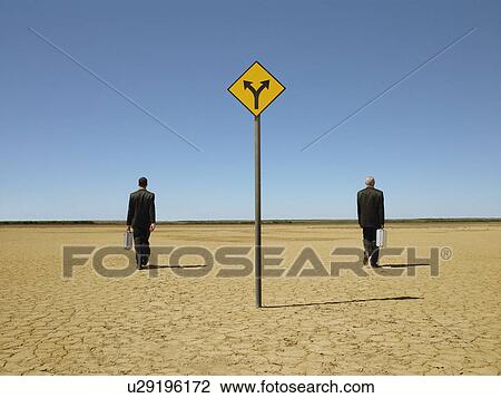 Two businessmen with briefcases in desert back view road sign in foreground View Large Photo Image Stock Image - Two businessmen with briefcases in desert back view road sign in foreground. Fotosearch