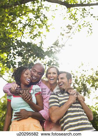 Two couples laughing in garden View Large Photo Image Stock Image - Two couples laughing in garden. Fotosearch