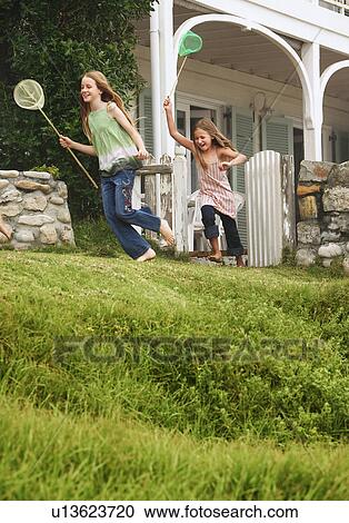 Two girls (7-9 10-12) holding fishing nets running in front of house View Large Photo Image Stock Image - Two girls (7-9 10-12) holding fishing nets running in front of house. Fotosearch