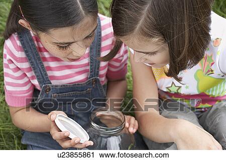 Two girls (7-9) examining jar of insects outdoors View Large Photo Image Stock Image - Two girls (7-9) examining jar of insects outdoors. Fotosearch