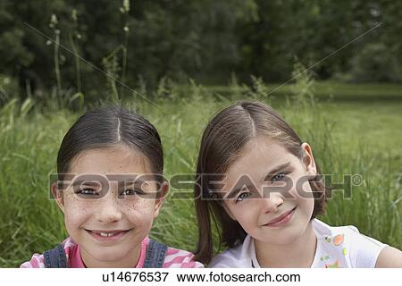 Two girls (7-9) smiling in field portrait View Large Photo Image Stock Photo - Two girls (7-9) smiling in field portrait. Fotosearch