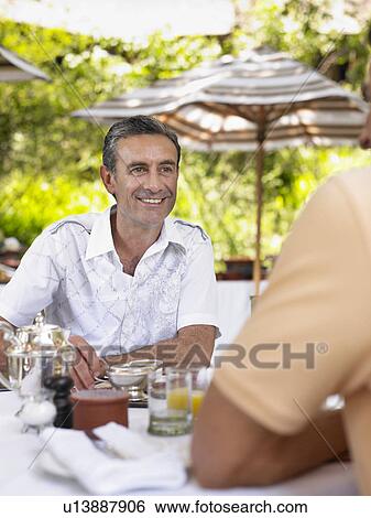 Two men having conversation at table selective focus View Large Photo Image Stock Photograph - Two men having conversation at table selective focus. Fotosearch