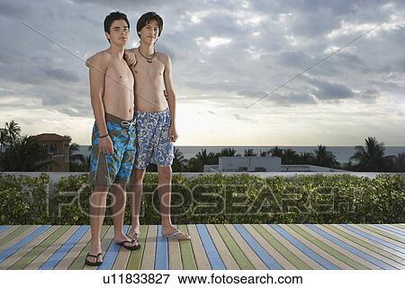 Two teenage boys (16-17) standing on wooden deck portrait View Large Photo Image Stock Photo - Two teenage boys (16-17) standing on wooden deck portrait. Fotosearch