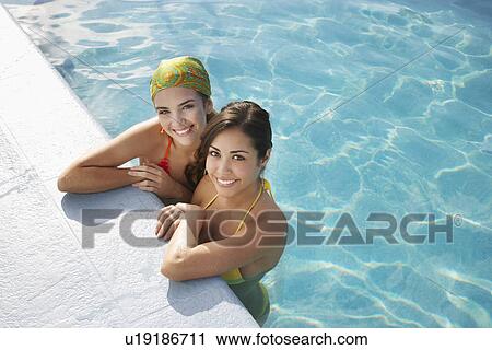 Two teenage girls (16-17) in swimming pool portrait elevated view View Large Photo Image Stock Image - Two teenage girls (16-17) in swimming pool portrait elevated view. Fotosearch