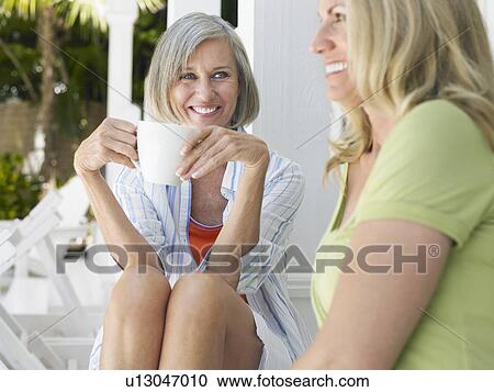 Two women sitting on verandah View Large Photo Image Stock Image - Two women sitting on verandah. Fotosearch