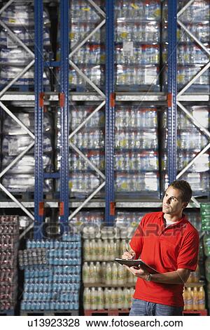 Stock Photo - Warehouse Worker Checking Inventory. Fotosearch