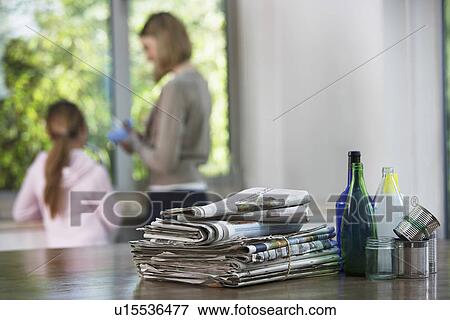 Waste paper and bottles on table woman and girl in background View Large Photo Image Stock Photo - Waste paper and bottles on table woman and girl in background. Fotosearch
