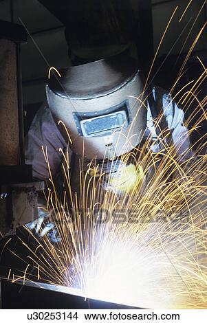 Picture - Welder wearing protective face mask welding at Work. Fotosearch