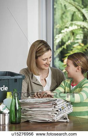 Woman and girl preparing waste paper for recycling smiling View Large Photo Image Stock Photograph - Woman and girl preparing waste paper for recycling smiling. Fotosearch