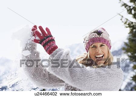 Stock Image - Woman catching snowball. Fotosearch