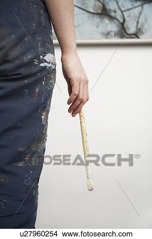 Woman holding paintbrush back view mid section View Large Photo Image Picture - Woman holding paintbrush back view mid section. Fotosearch
