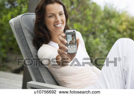 Woman holding up picture message sitting on porch View Large Photo Image Stock Image - Woman holding up picture message sitting on porch. Fotosearch