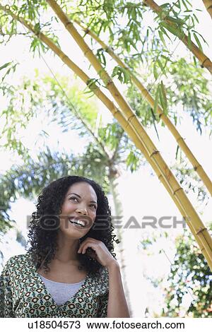 Stock Image - Woman in bamboo forest low angle view portrait. Fotosearch