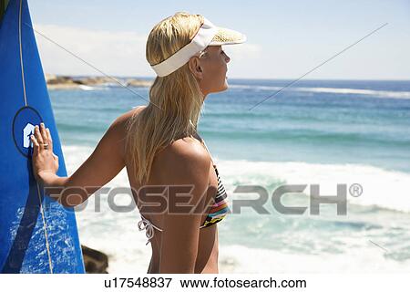 Woman in bikini with surfboard at beach half length View Large Photo Image Stock Photo - Woman in bikini with surfboard at beach half length. Fotosearch
