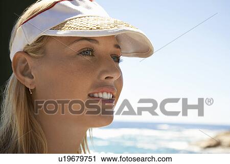 Woman in sun visor at beach head and shoulders close up View Large Photo Image Stock Image - Woman in sun visor at beach head and shoulders close up. Fotosearch