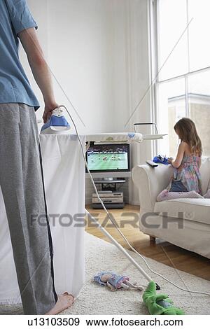 Woman ironing (low section) daughter (5-6) playing on sofa View Large Photo Image Stock Photo - Woman ironing (low section) daughter (5-6) playing on sofa. Fotosearch
