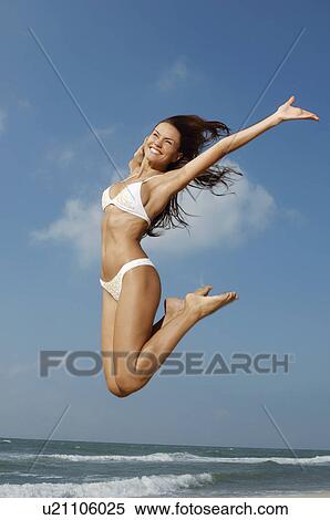 Woman jumping on beach mid-air View Large Photo Image Stock Photography - Woman jumping on beach mid-air. Fotosearch