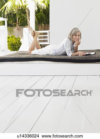 Woman lying down on daybed on verandah portrait View Large Photo Image Picture - Woman lying down on daybed on verandah portrait. Fotosearch