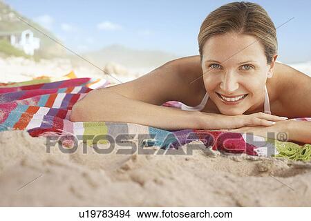 Picture - Woman lying on beach portrait. Fotosearch
