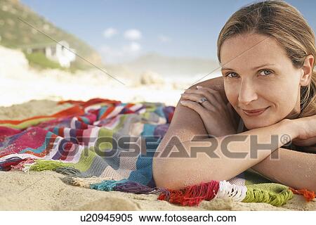 Stock Photography - Woman lying on beach portrait. Fotosearch