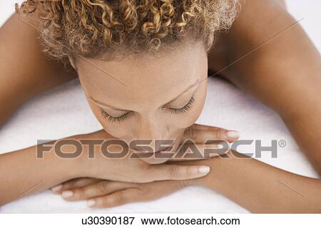 Stock Photo - Woman lying on massage table head and shoulders view from above. Fotosearch