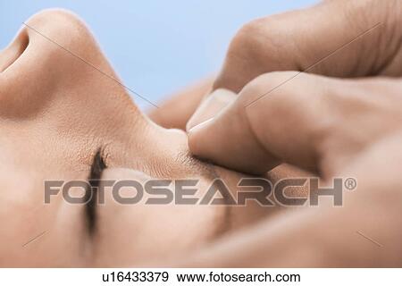 Stock Photo - Woman receiving massage close-up of upper face. Fotosearch