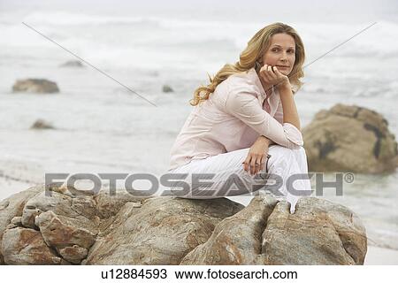 Stock Image - Woman Relaxing on Beach. Fotosearch
