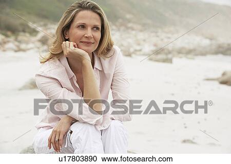 Stock Image - Woman Relaxing on Beach. Fotosearch