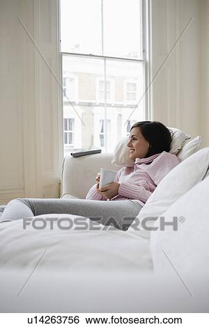 Stock Photograph - Woman Relaxing on Sofa. Fotosearch